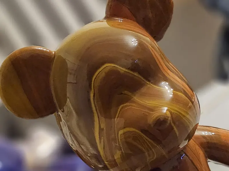 Nahaufnahme eines Fluid-Art-Bären: Karamell, Gold und Braun fliessen in feinen Adern ineinander